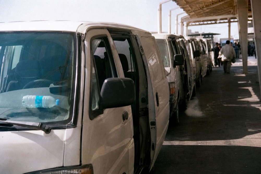 Tour vans lined up at the Ensenada cruise terminal waiting for arriving passengers, no text, no logos, no people