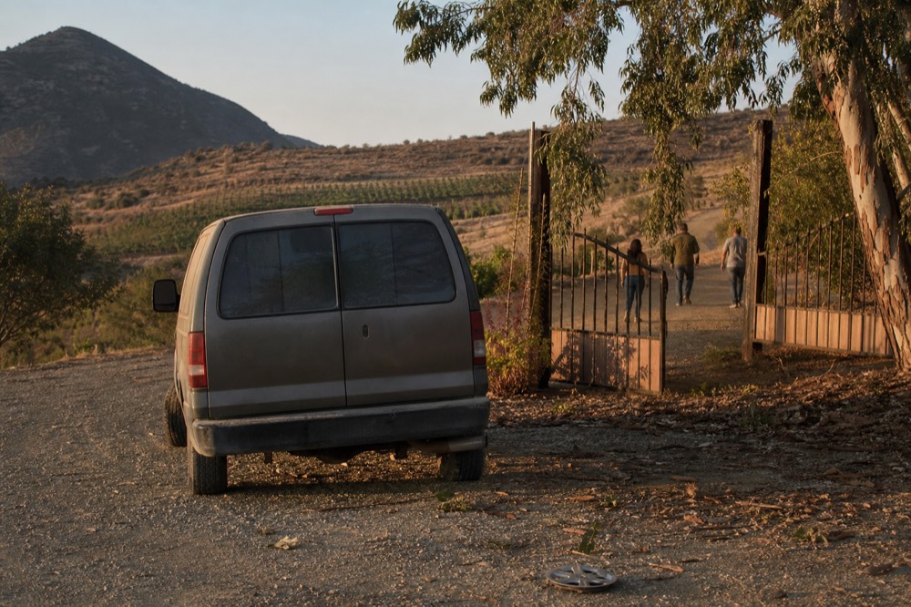 Private tour van parked at a winery entrance in the hills above Ensenada, no text, no logos, no people
