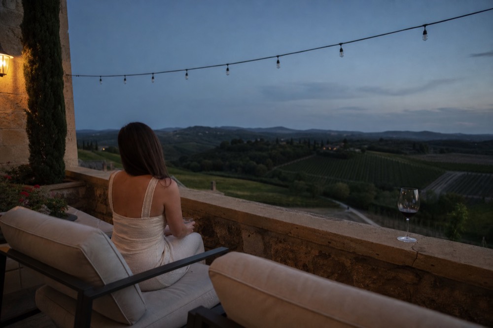 Boutique hotel terrace overlooking rolling vineyard hills at dusk, no text, no logos, no people