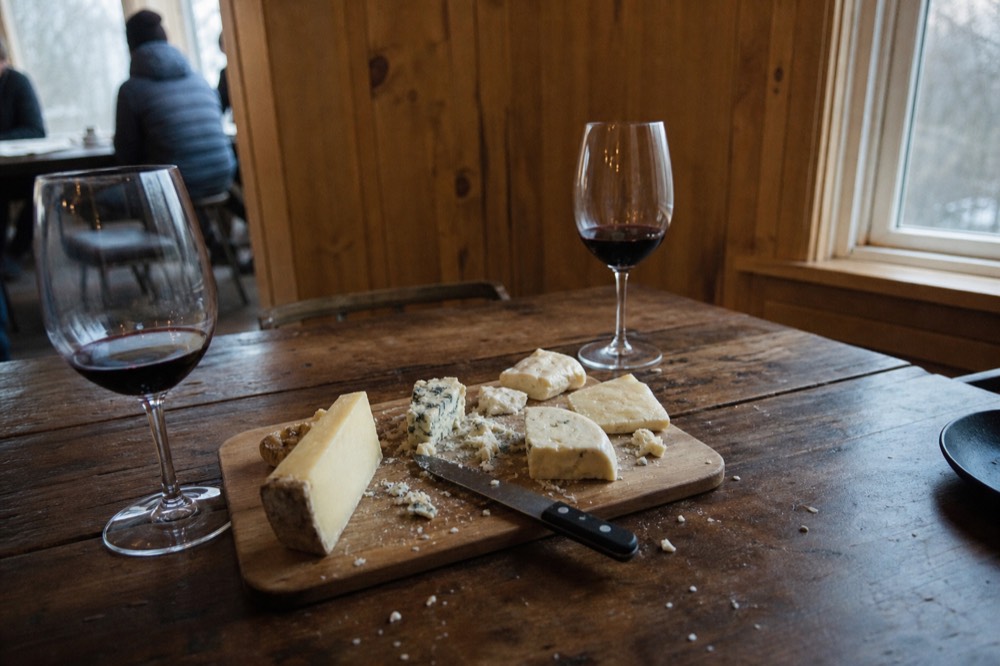 Rustic cheese board and wine glasses on a wooden table, no text, no logos, no people