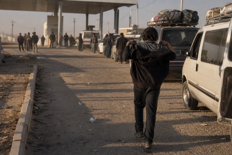 Vehicles queued near the US-Mexico border crossing in late-afternoon light