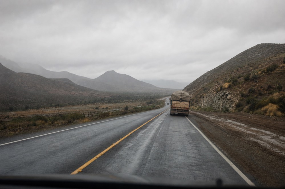 A road winding through dry Baja hills toward the wine valley, no text, no logos, no people