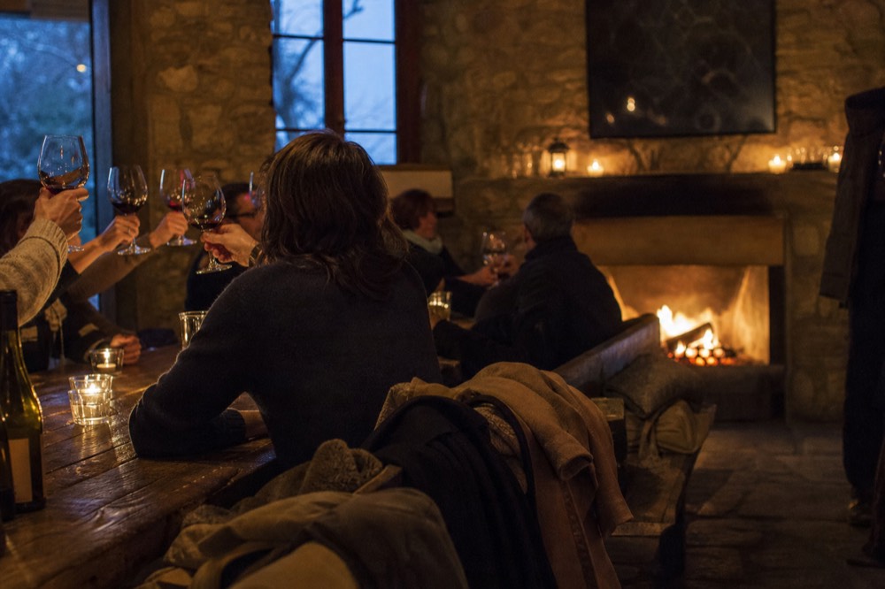 A small group toasting glasses inside a warm tasting room, no text, no logos, no people