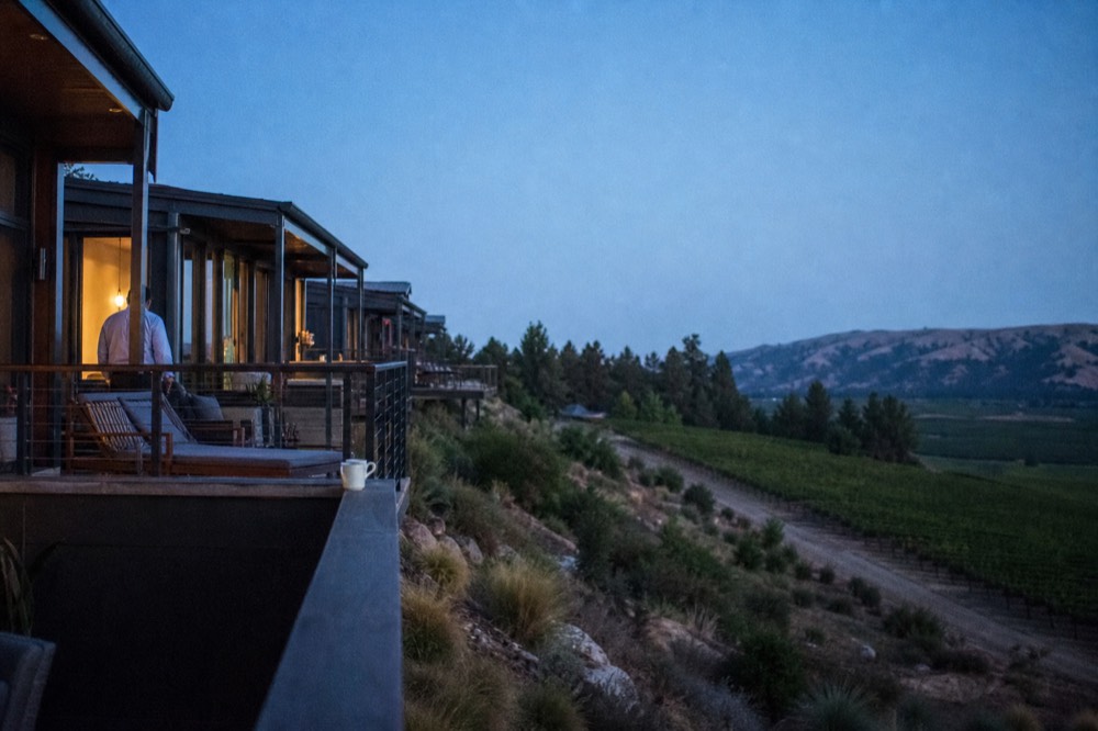 Modern lofts terraced into a hillside above vineyards, no text, no logos, no people