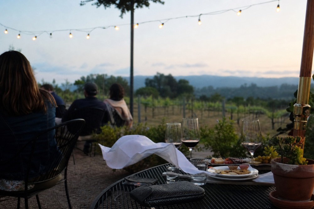 A table set with wine glasses and small plates at an outdoor tasting terrace, no text, no logos, no people.