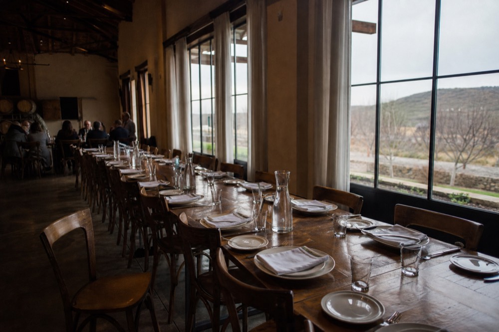 A long table set for lunch inside a Baja California winery dining room, no text, no logos, no people