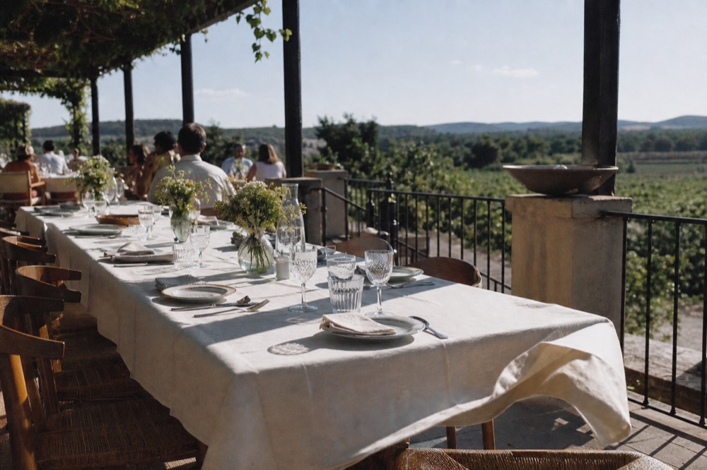 A long shared table set for brunch on an open restaurant terrace, no text, no logos, no people